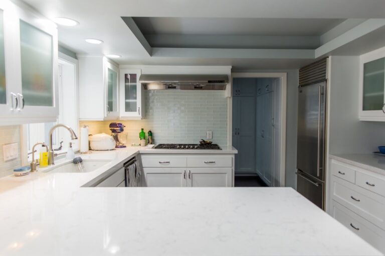 Modern Los Angeles kitchen with white cabinets, stainless appliances, and a refreshed marble countertop.
