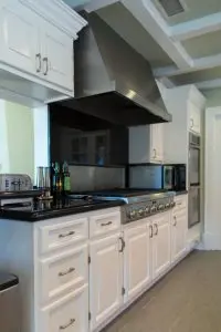 Modern kitchen with a cabinet refresh: white cabinets, stainless steel appliances, and sleek black countertops.
