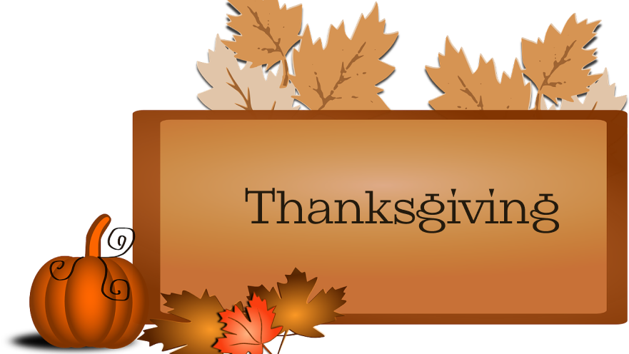 A sign with Thanksgiving written on it, featuring autumn leaves, a pumpkin, and a rustic stain finish.