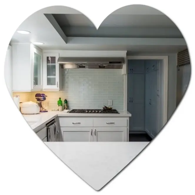 Heart-shaped image of a modern white kitchen with a cabinet refresh, stove, and stylish tiled backsplash.